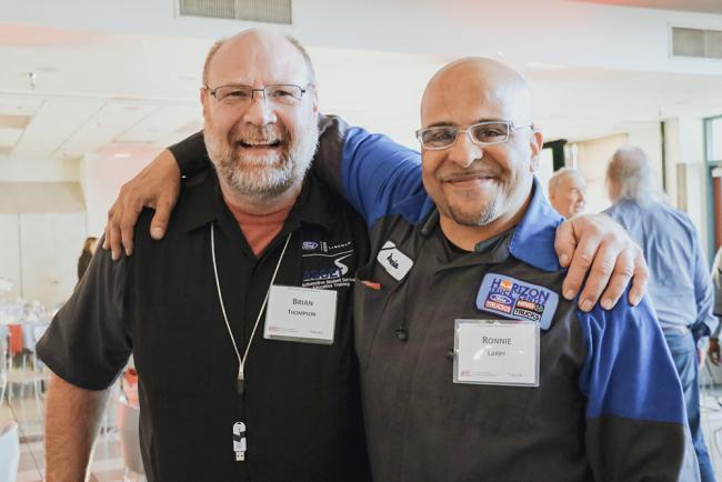 Ford Asset Instructor Brian Thompson smiling with Foundation Scholar Ronnie Larry at the Foundation's Annual Breakfast.